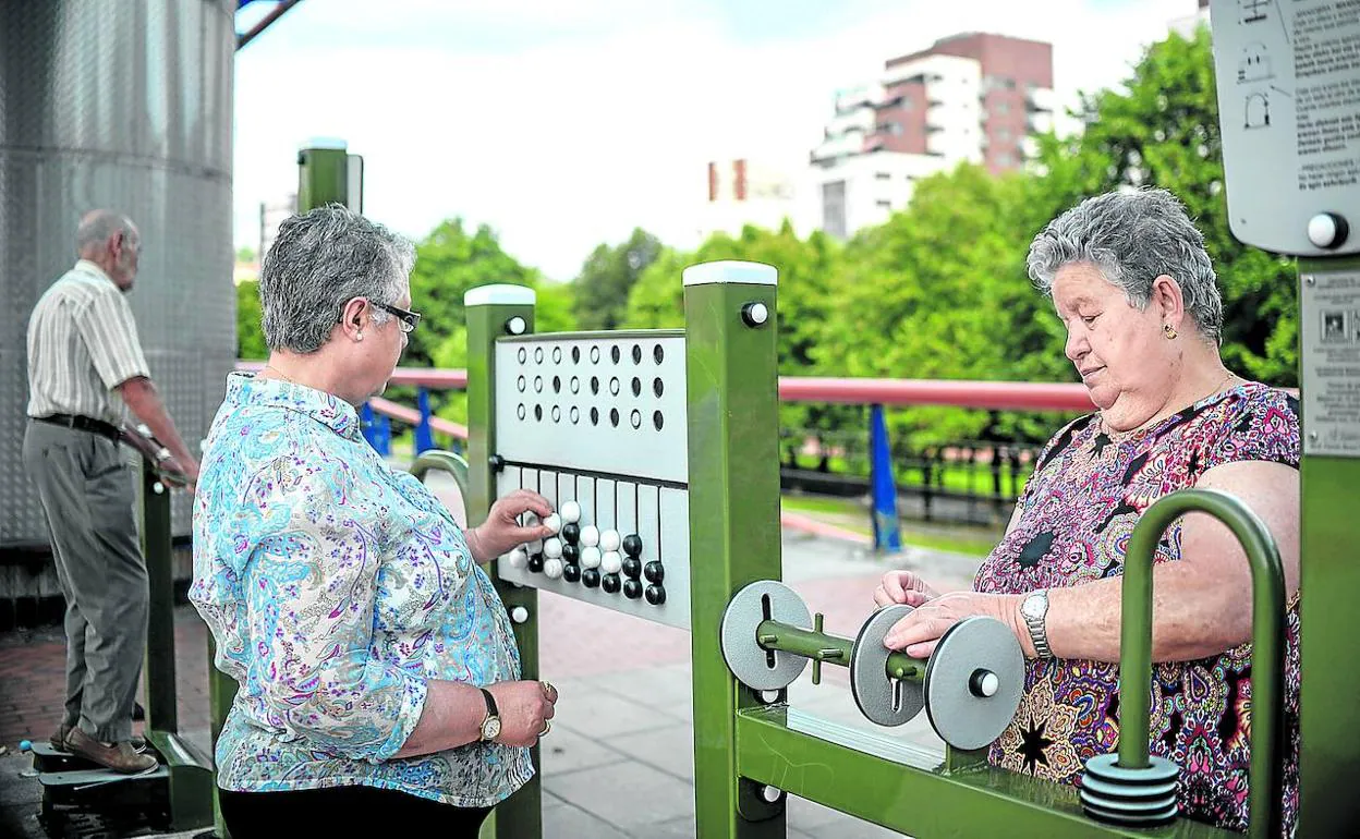 Yolanda y Mari Paz conversan mientras utilizan dos de los juegos de ingenio que el Ayuntamiento ha instalado en el parque de Amézola.