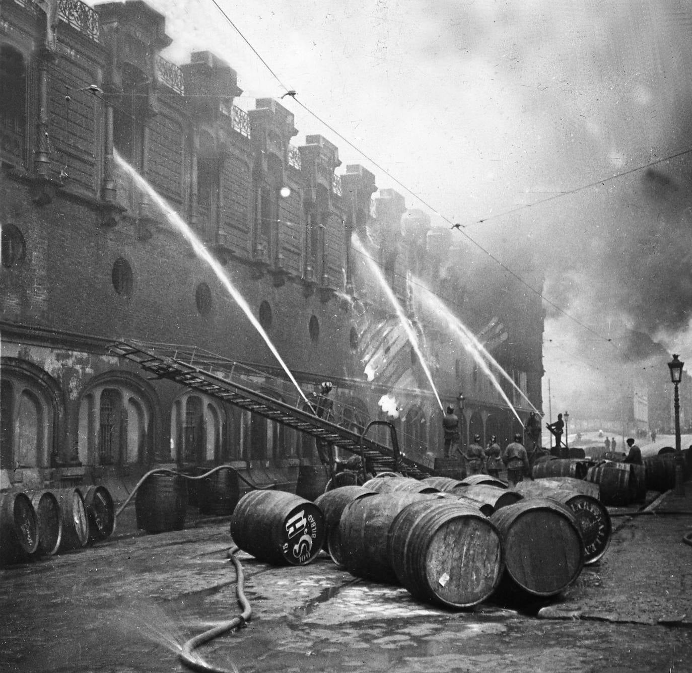 Los bomberos tratan de apagar las llamas del incendio que arrasó la Alhóndiga en 1919.