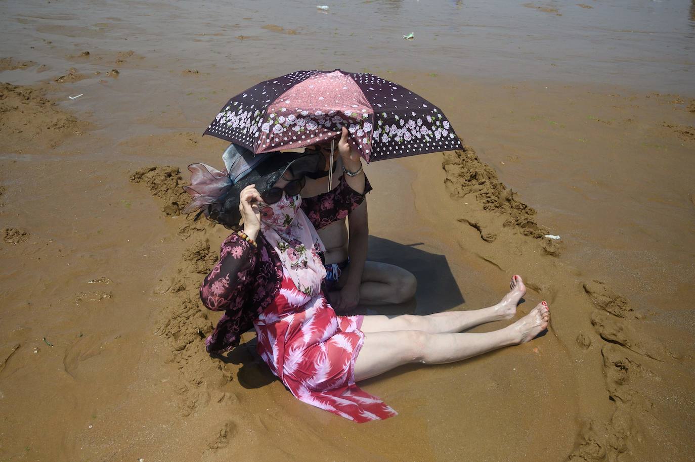 La playa de Qingdao en la provincia de Shadong, es una de las playas más concurridas de China. Aquí, la gente, busca un lugar donde refrescarse del azotador calor