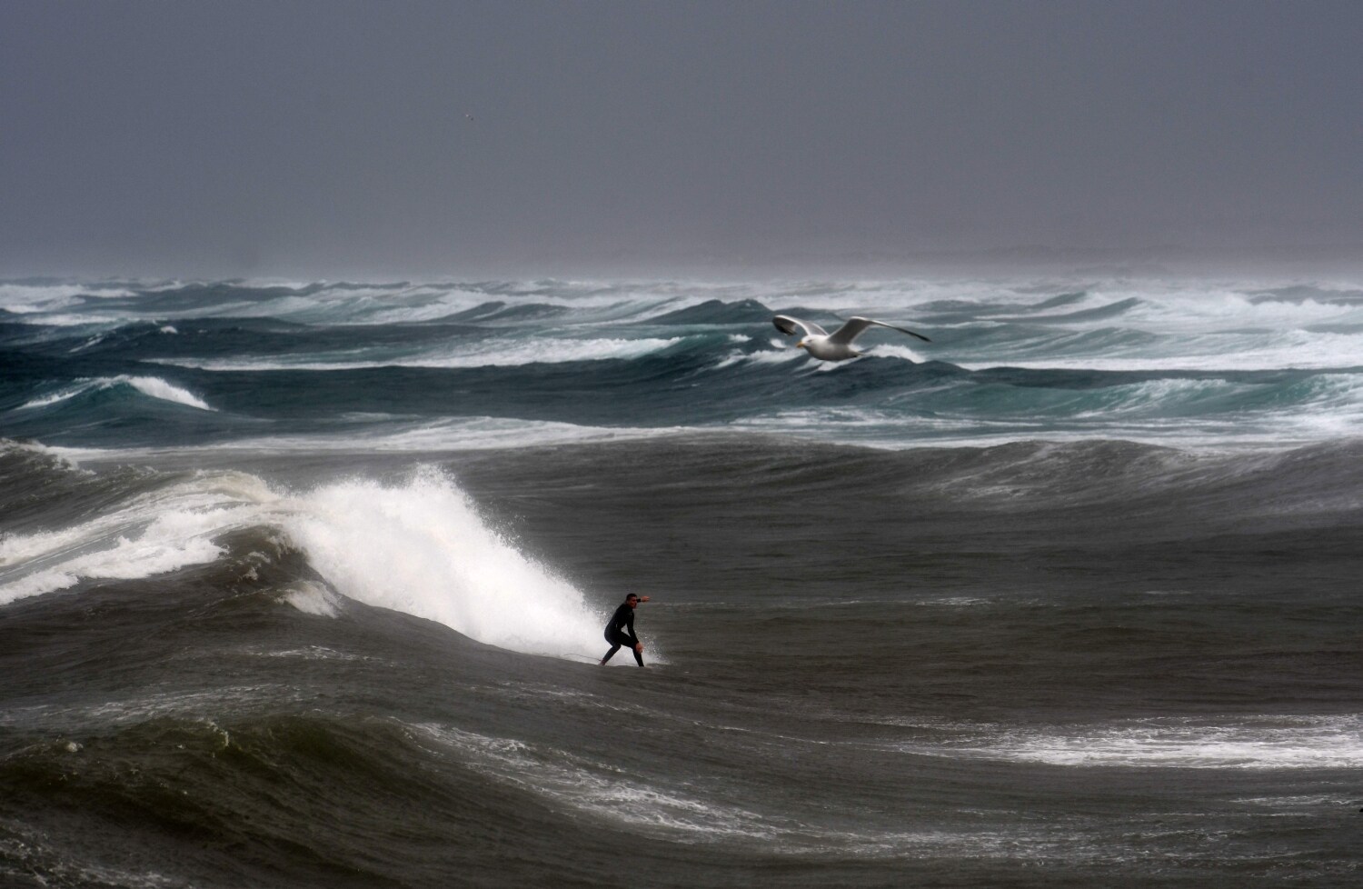 Un hombre surfea una ola en Pointe-de-la-Torche en Plomeur, oeste de Francia, cuando los fuertes vientos golpean la costa. 