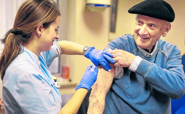 Una enfermera de Osakidetza inyecta la vacuna contra la gripe a un usuario en un centro de salud vasco.