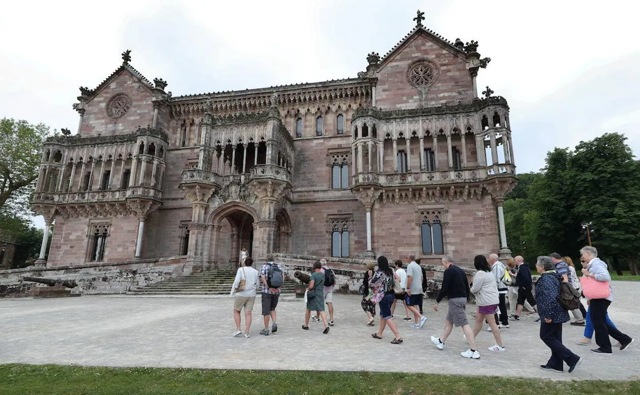 Un grupo de visitantes se dirige hacia el palacio. 
