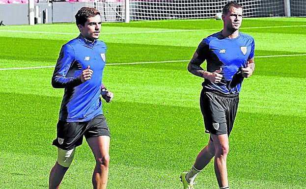 Córdoba, con un vendaje en su rodilla derecha, e Íñigo Martínez se ejercitan ayer al margen en San Mamés.