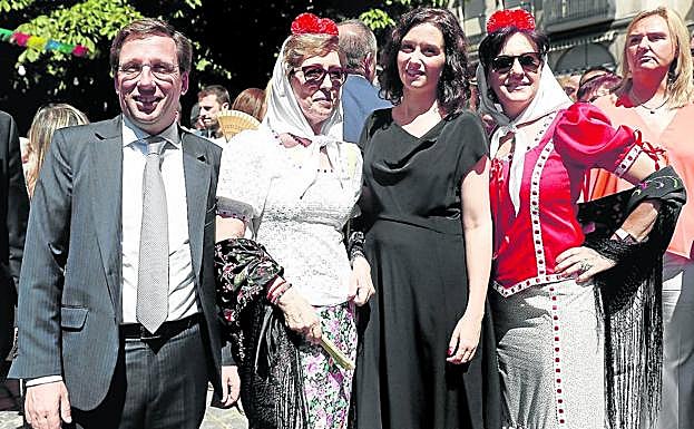 La presidenta Díaz Ayuso y el alcalde de Madrid, José Luis Martínez Almeida, posan con dos asistentes a las fiestas de La Paloma.