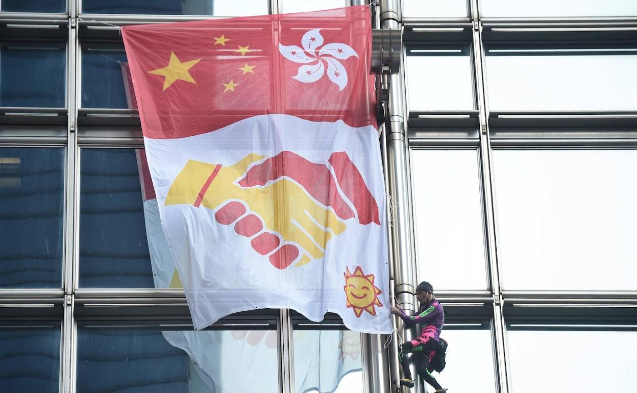 El escalador Alain Robert, conocido como el 'Spiderman francés', cuelga una bandera de la paz en el edificio Cheung Kong Center de Hong Kong.