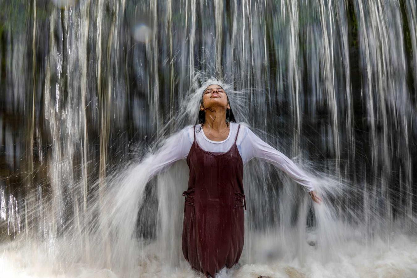 Una mujer se refresca bajo una catarata en Bhaktapur (Nepal)