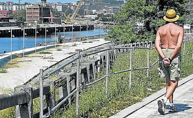 Un paseante, a la altura del parque de Sarriko, deja a su izquierda el paseo que se está urbanizando junto al canal de Deusto.