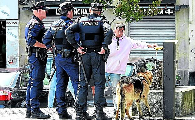 El joven agredido, junto a su perro 'Tor', charla con ertzainas ayer en Corazón de María.