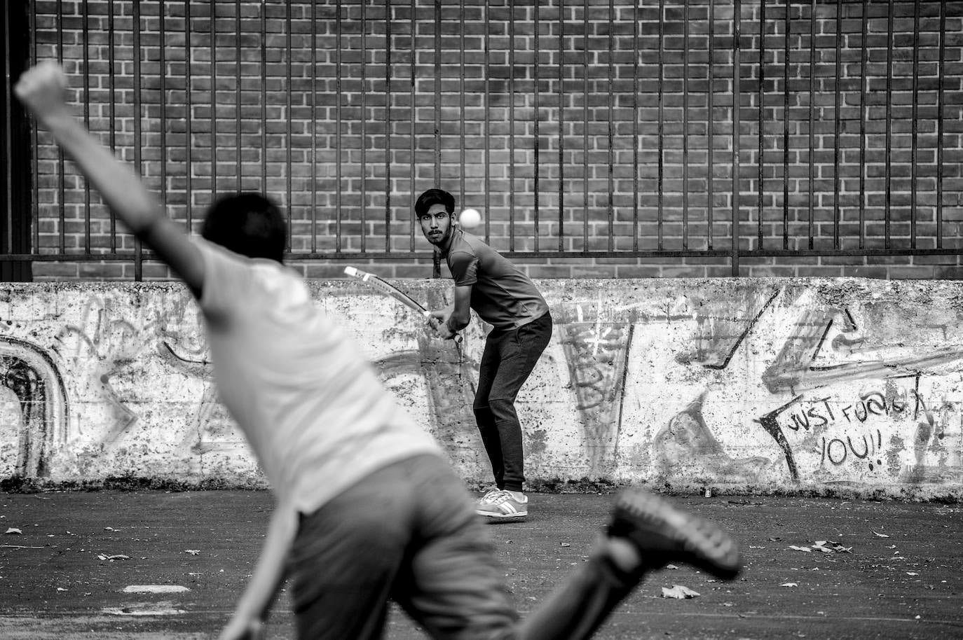 Dos jóvenes de origen pakistaní juegan al cricket en los campos deportivos de Los Herrán.