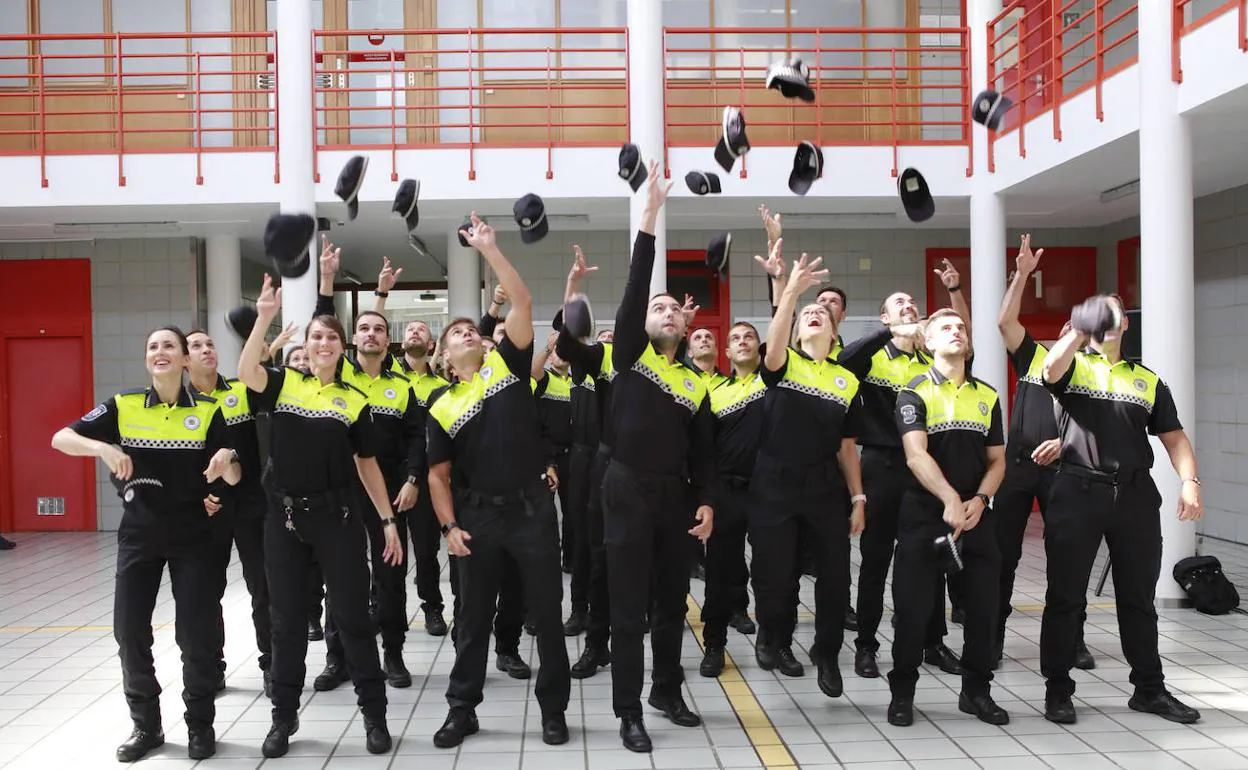 Los nuevos agentes lanzan sus gorras al aire.