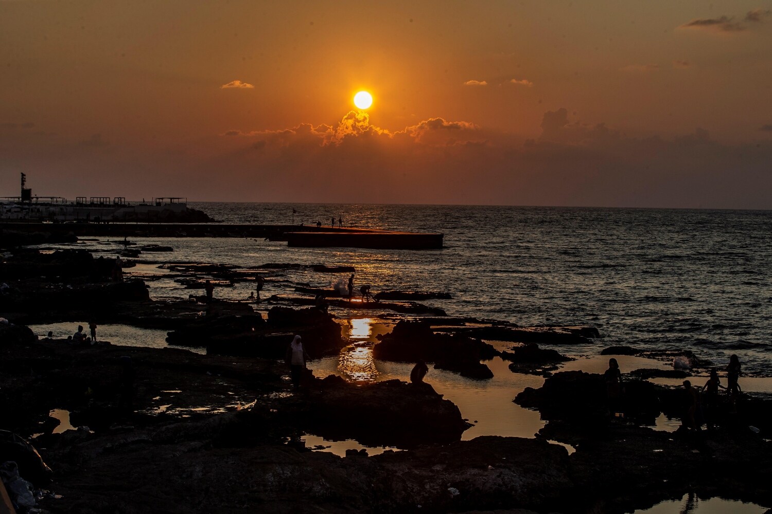 Varias personas en la playa del Mediterráneo durante la puesta de sol en Beirut (Líbano).