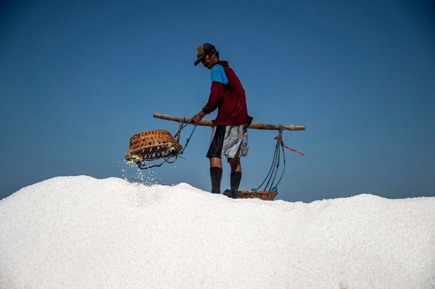 Trabajador indonesio cosechando sal en Sidoarjo, provincia de Java Oriental. 