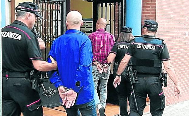 Los detenidos entran, ayer, en el piso para asistir al registro de la vivienda.
