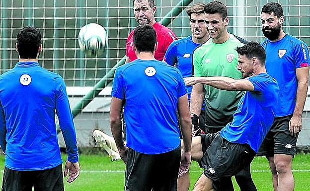 Aduriz, quien se quedó fuera de la convocatoria, golpea el balón ayer en Lezama rodeado de sus compañeros.
