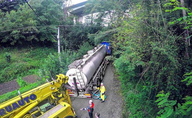 Un camión grúa garantizó que el vehículo se mantuviese estable y no cayese al riachuelo junto a la calzada.