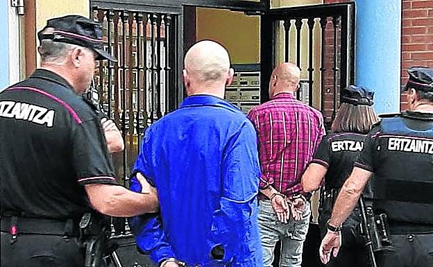 Dos de los detenidos acompañan a la Ertzaintza al registro de su vivienda.