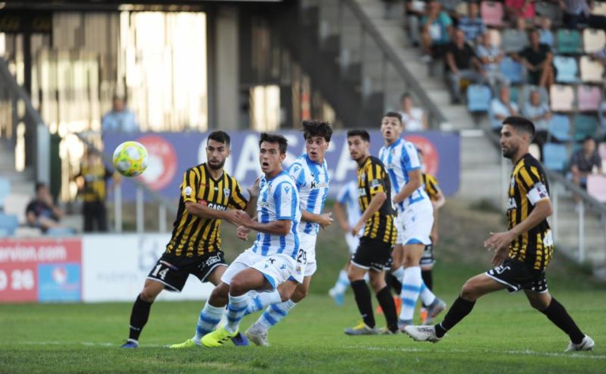 Varios jugadores luchan por un balón.