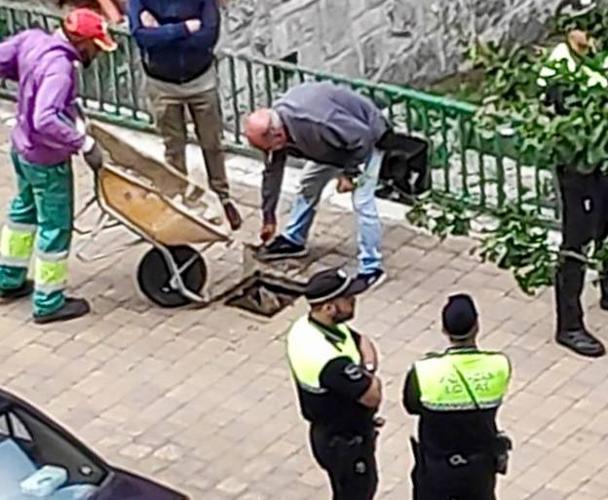 Policías locales escoltan a técnicos municipales durante el sellado de las arquetas de Olárizu.