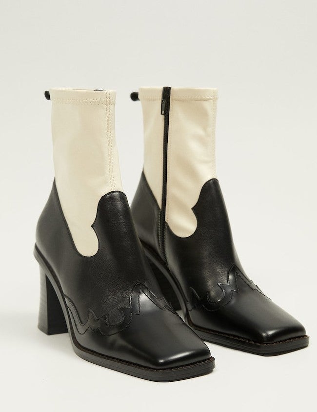 Botines cowboy de piel combinada en blanco y negro, de punta cuadrada y tacón ancho, que están a la venta en la tienda online de Mango por 69,95 euros. 