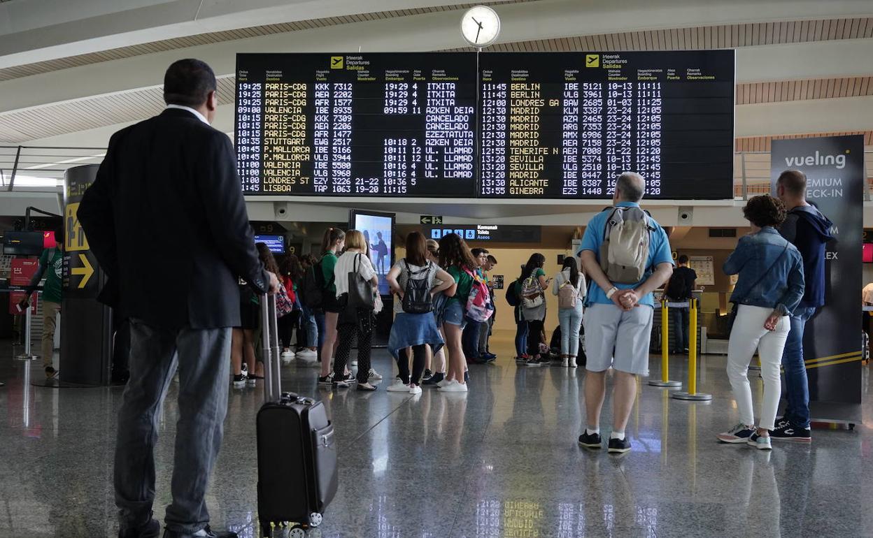 Usuarios del aeropuerto de Loiu en una foto de archivo comprobando el horario de sus vuelos. 