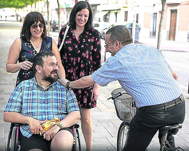 Amores, acompañado por dos concejalas, recibe el saludo de un vecino.