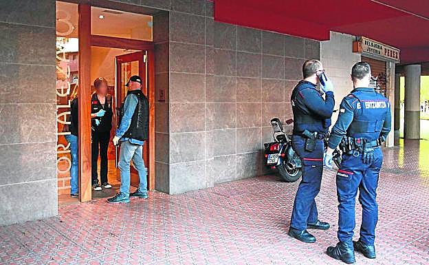 Ertzainas en el portal donde los dos acusados presuntamente asaltaron a Pilar Arbulo.