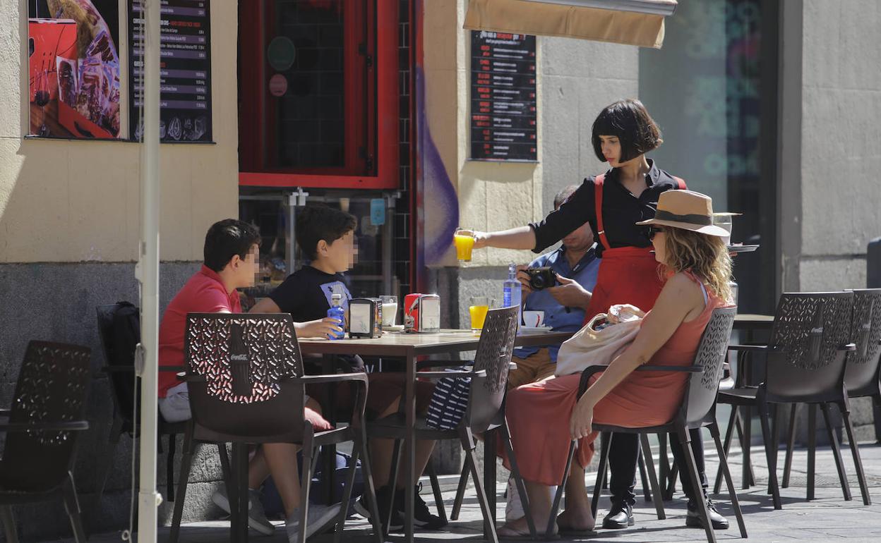 Una camarera atiende una terraza en Madrid.