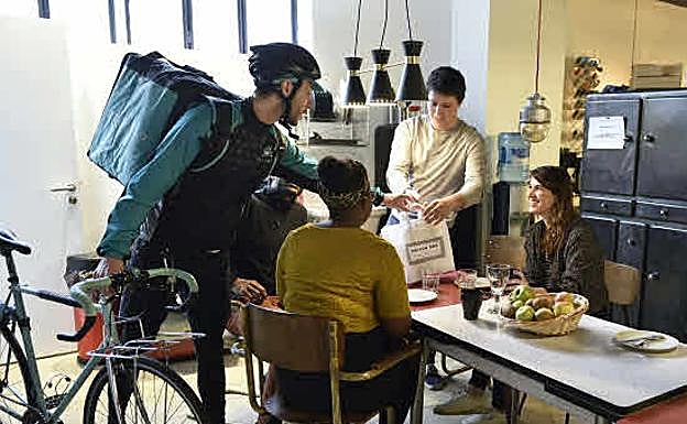 Un rider reparte un pedido en una oficina de París.