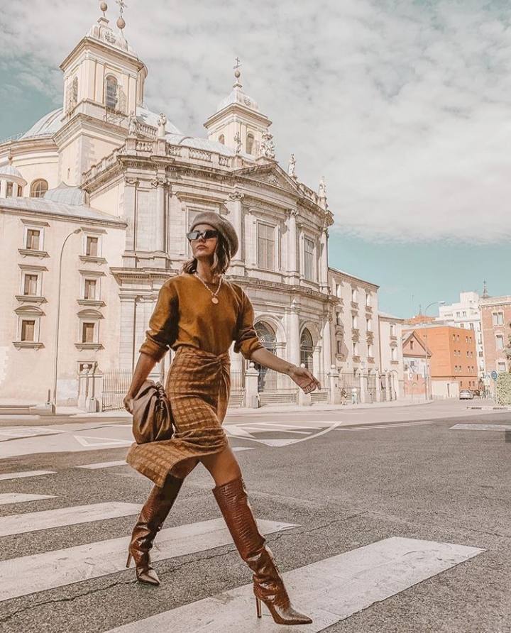 Alexandra Pereira prefiere combinar diferentes tonalidades de marrón, en este look formado por falda de cuadros con abertura, jersey básico y botas de caña alta con piel grabada.