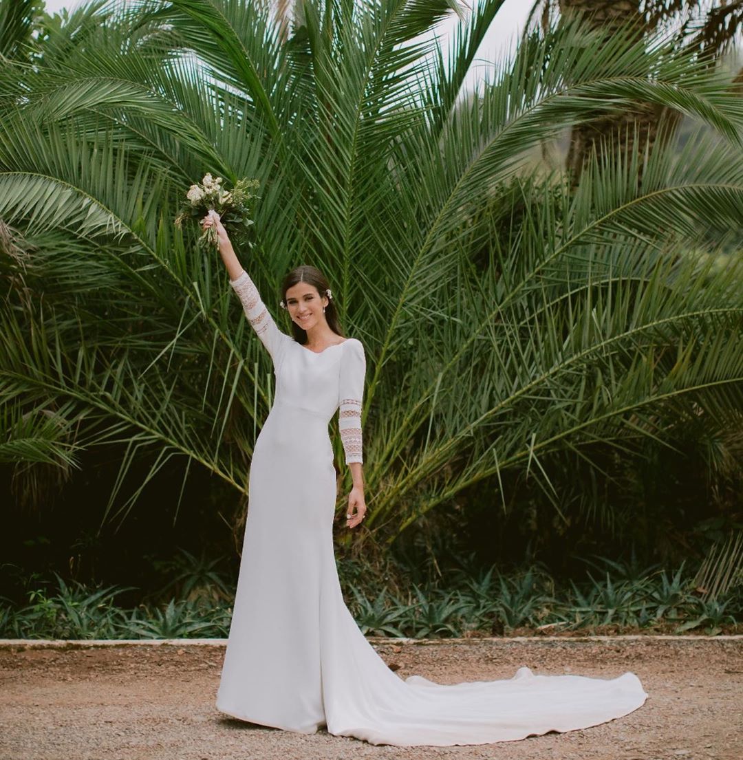 La periodista y modelo Sandra Gago se casó hace poco menos de un mes con el tenista Feliciano López, en una íntima ceremonia celebrada en Marbella. En su caso, apostó por dos vestidos firmados por Jesús Peiró. El primero, con el que dio el ‘sí quiero’, llevaba por nombre ‘Celosía’ y era un diseño confeccionado en crep y chantilly, con escote barco y manga francesa. Además, llevó un tocado de cristal de Murano y Swarovski, del cual prescindió durante el momento del baile. Para la fiesta posterior, cambió su vestido por un dos piezas con cuerpo crop de escote halter y falda de talle alto con abertura frontal, perfecto para bailar toda la noche.