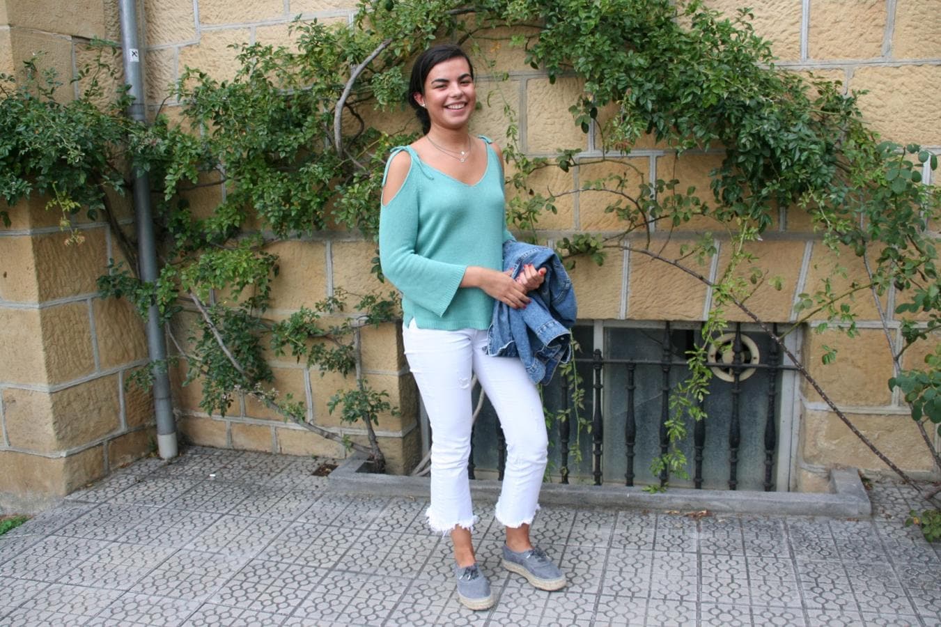 María Carranza, de 19 años, define su estilo como “casual”. Luce unos pantalones blancos de la firma Rennata & Go, que ha combinado con un jersey verde con los hombros descubiertos y unas zapatillas, ambos de Brownie. La chaqueta vaquera es de Pull & Bear.