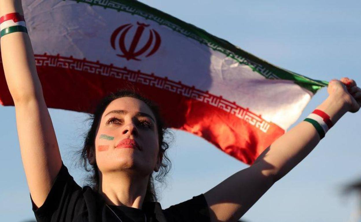 Iraní portando una bandera de su país, que permitió hace unos días la entrada de mujeres a los estadios después de 40 años. 