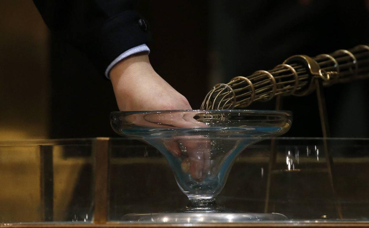 Una niña de San Ildefonso junto al bombo durante el sorteo de la Lotería de Navidad 2014