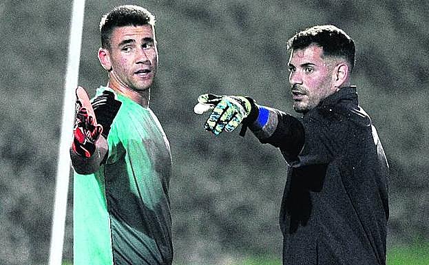 Unai Simon y Herrerín conversan durante el entrenamiento de ayer en Lezama.