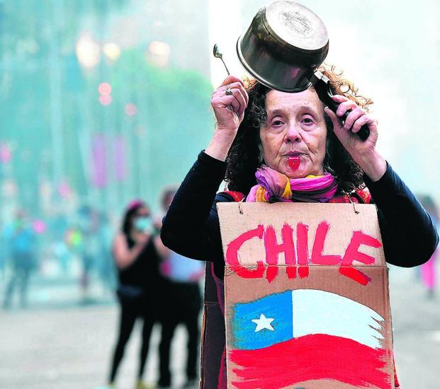 Una mujer participa en una cacerolada contra el Gobierno chileno de Sebastián Piñera, que ha tenido que retirar sus medidas económicas más impopulares.