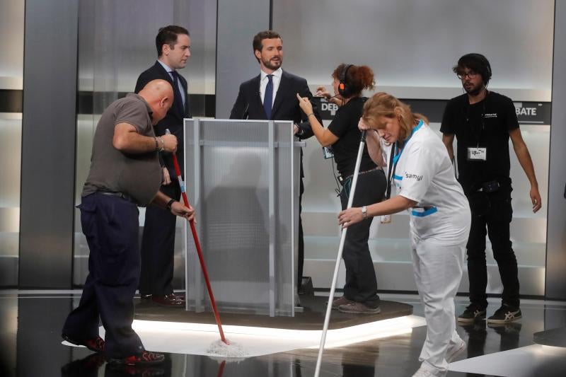 Trabajadores del programa limpian el plató frente a Casado, durante un momento del debate.