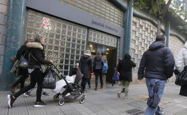 Varios padres esperan a sus hijos a las puertas del colegio. 