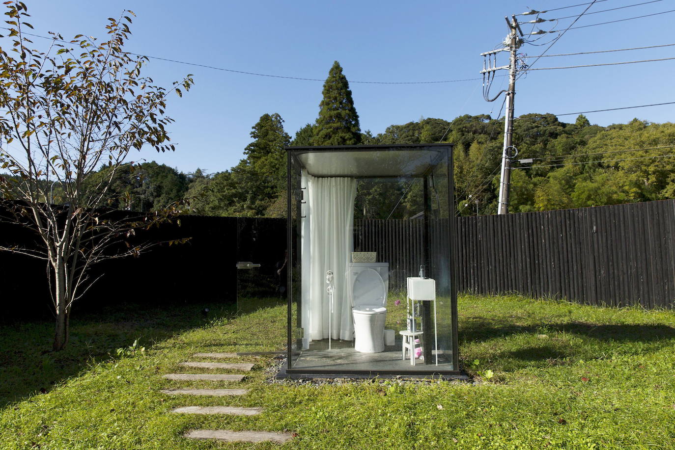 Un inodoro con paredes de vidrio, en un jardín cercado a la estación de tren de Itabu, al este de Tokio.