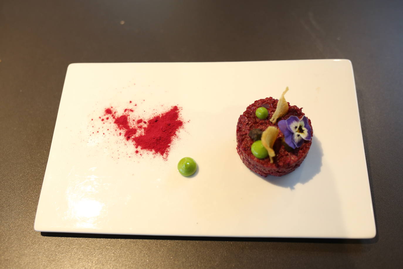 Menu 1 | Primer plato: tartare vegetal. Ingredientes: remolacha, aceite, cebollinos, mayonesa, alcaparras, flores de pensamiento, caviar de aceite de oliva y láminas de pan de maíz.