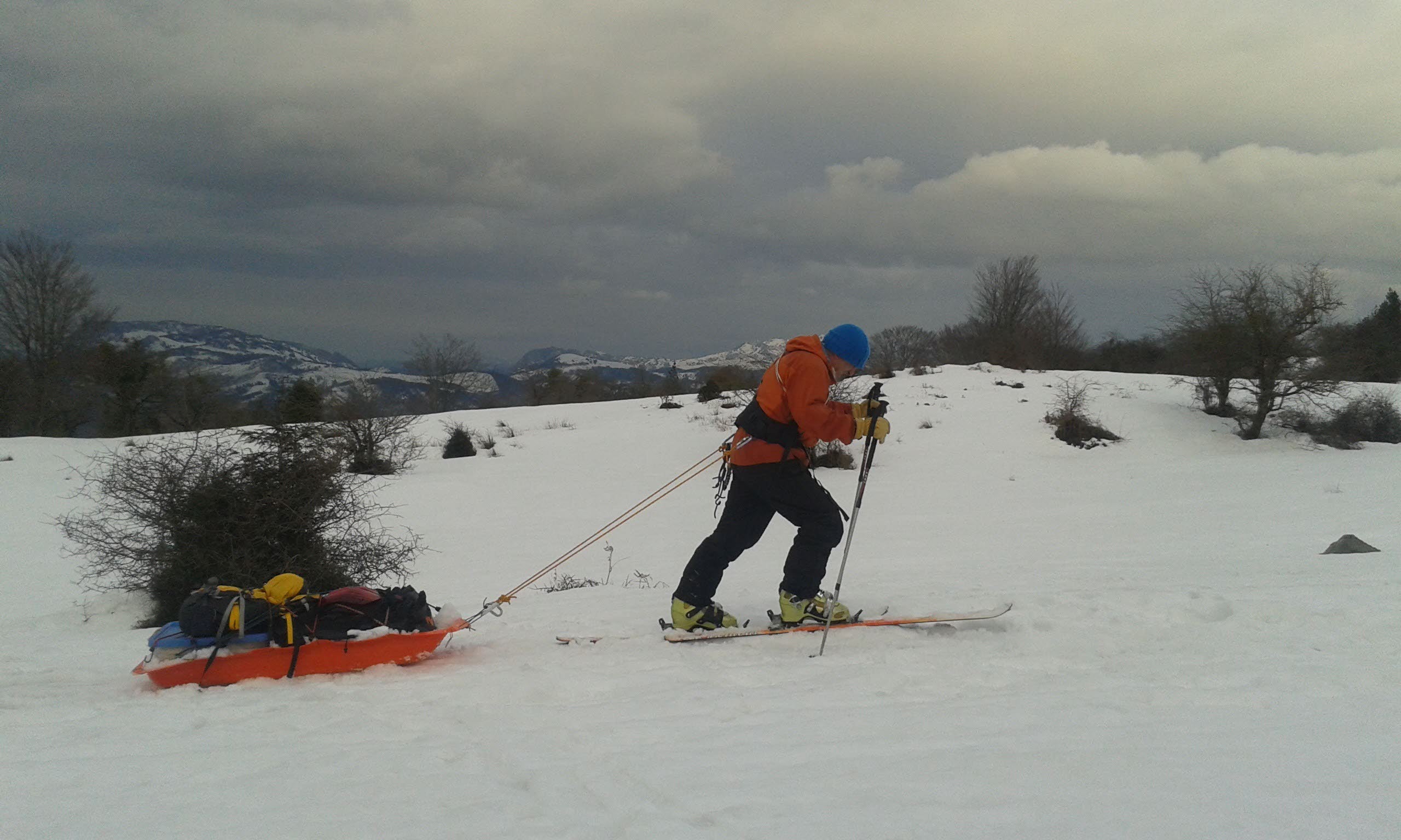 Un hombre sube al Gorbea arrastrando un trineo.