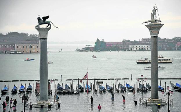 Puerta abierta al agua. Los visitantes acceden a la ciudad entre las columnas de San Marco y San Teodoro, que en la imagen emergen del mar por efecto del 'agua alta'. 