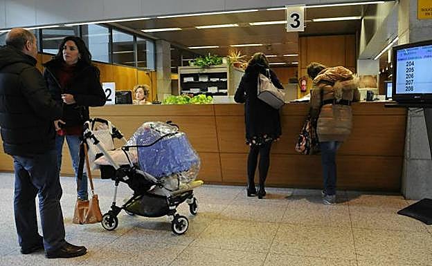 Una pareja con un carro espera su turno en las oficinas forales de Hacienda.