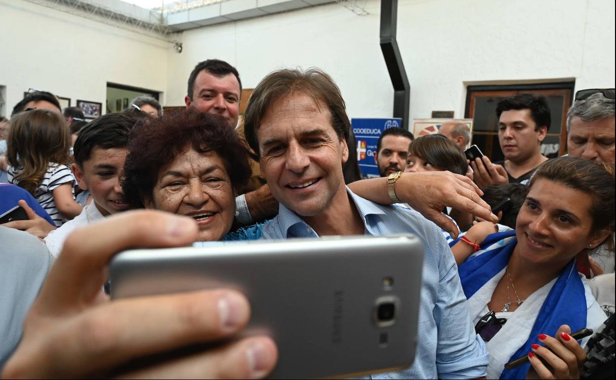 Lacalle se fotografía con una seguidora después de votar en las presidenciales de Uruguay.