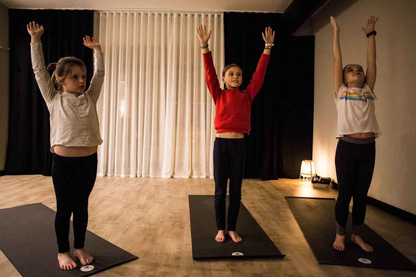 Tres niñas realizan estiramientos.