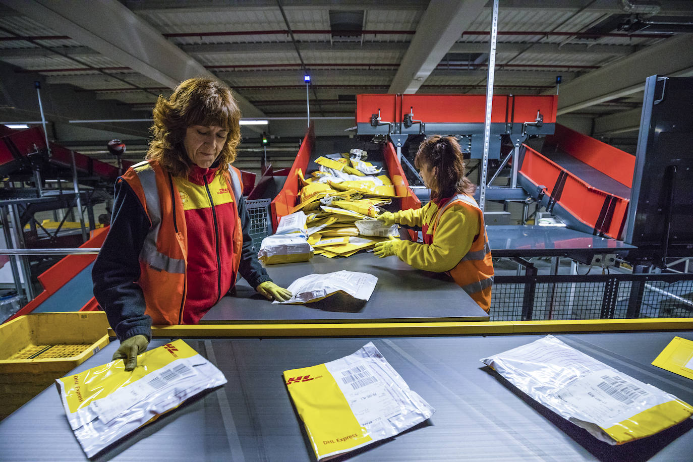 Empleadas colocan en la cinta los 'flyers' (sobres).