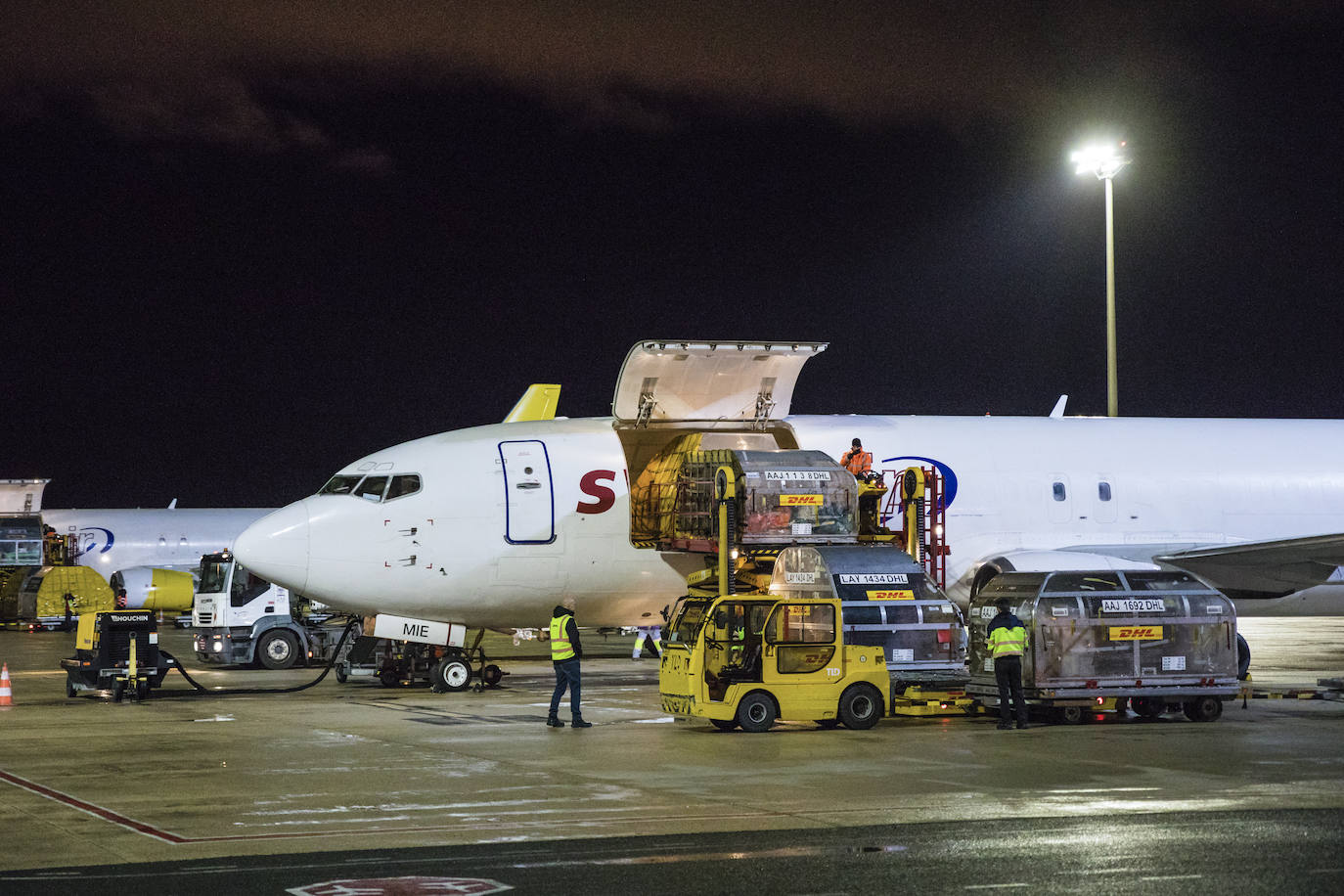 Operarios descargan la mercancía de los contenedores que llegan en los aviones.