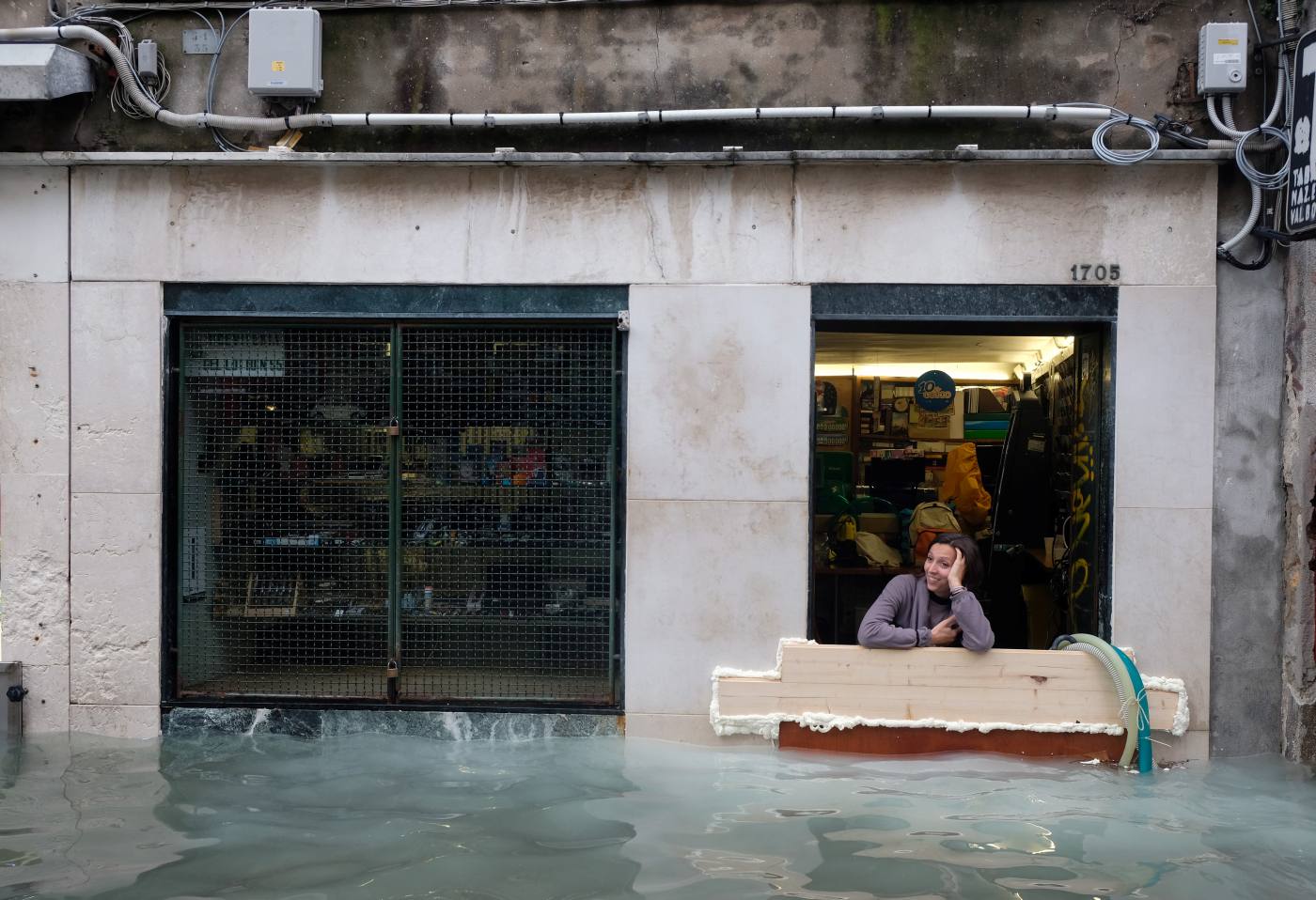 Una mujer, en la puerta de su tienda, en plena época de agua alta en Venecia.