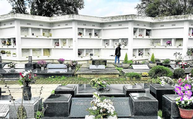 Una mujer lleva flores a un familiar enterrado en El Salvador el día de Todos los Santos.