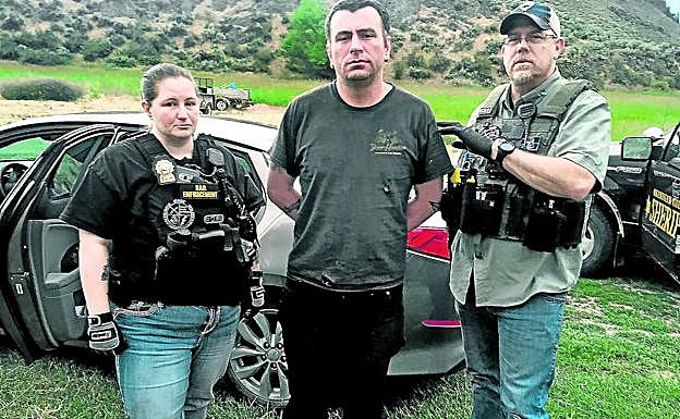 Gribbles y una integrante de su equipo, en la frontera de Idaho con Canadá, custodian a un fugitivo al que acaban de capturar, acusado deposesión de drogas.