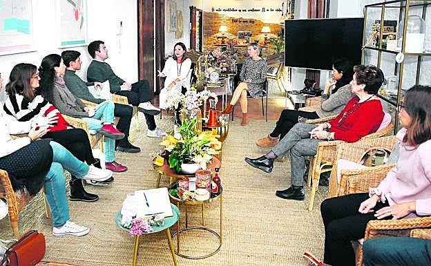Teté García, al fondo y de blanco, se dirige al resto de asistentes al último Death Cafe del año en Valencia.